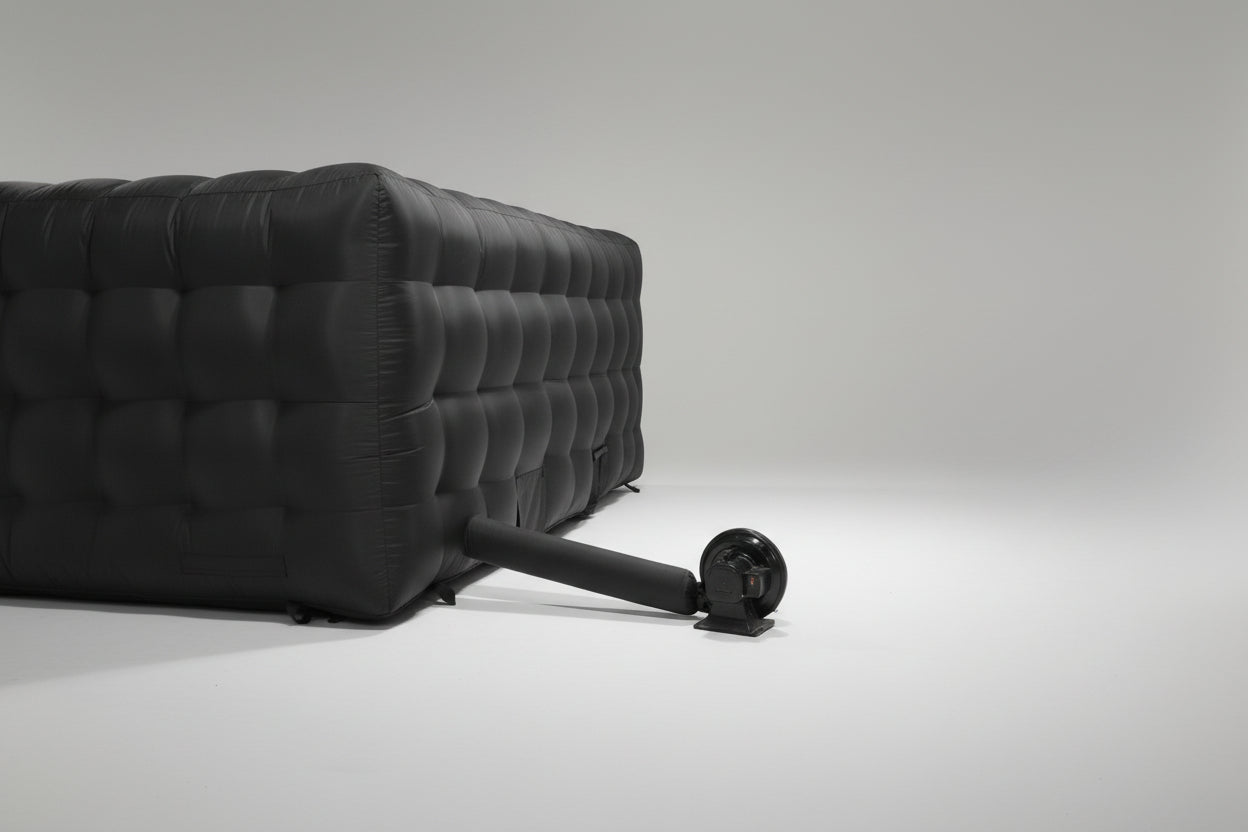 An inflatable nightclub tent enclosure in a warehouse setting, predominantly dark colored with a textured surface. Perfect for events, parties, intimate nightclub.