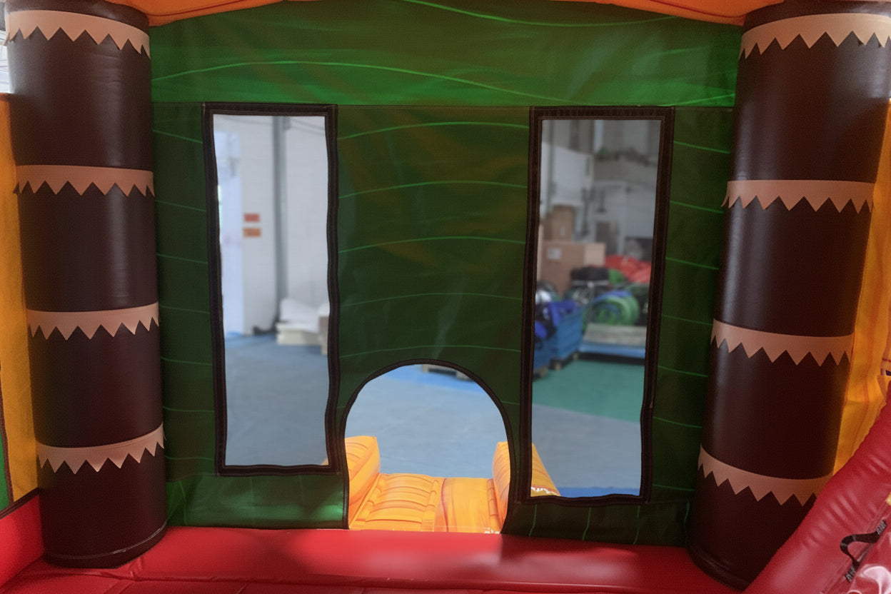 A colourful inflatable bouncy castle with a tropical theme, featuring two slides and a ball pit area