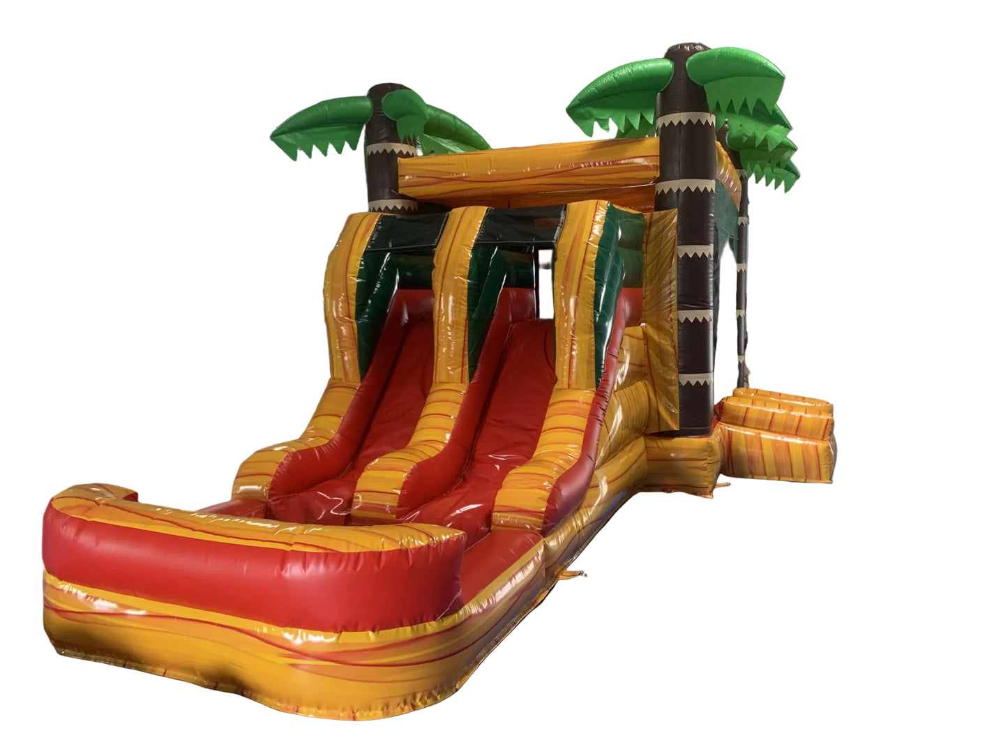 A colourful inflatable bouncy castle with a tropical theme, featuring two slides and a ball pit area