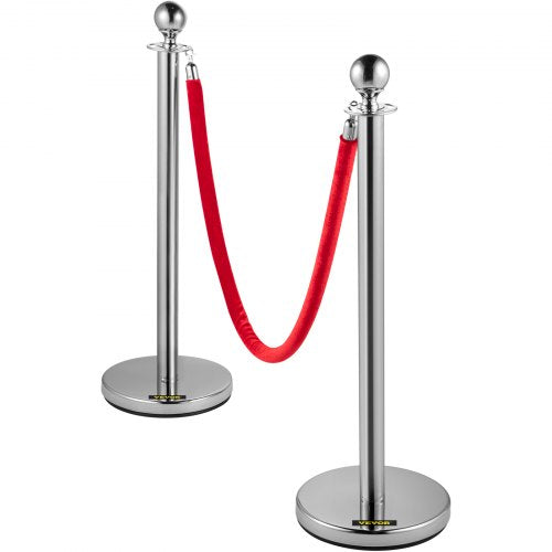 A set of silver stainless steel crowd control stanchions with red velvet ropes.