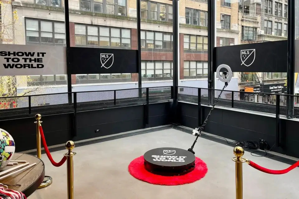 Indoor sports facility with a mental 360 Photobooth on a red mat, surrounded by ropes and barriers, with 'Show It to the World' branding.