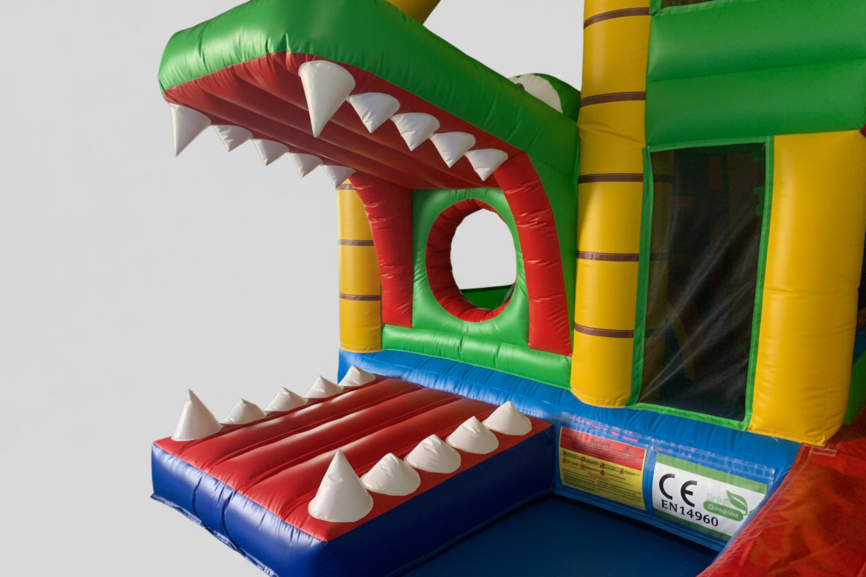 Colorful inflatable crocodile slide with CE and EN14960 labels in an indoor setting.