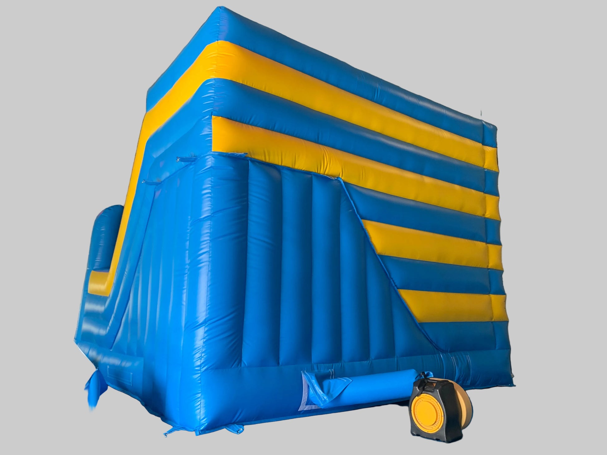 Blue and yellow inflatable bounce house on a gray background