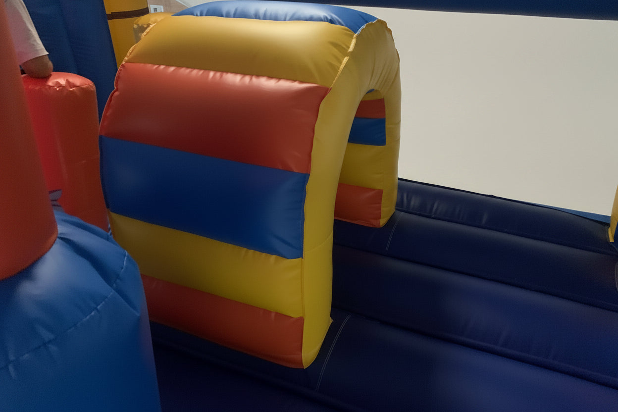 Colorful bouncy house with red, yellow, and blue sections in an indoor setting.