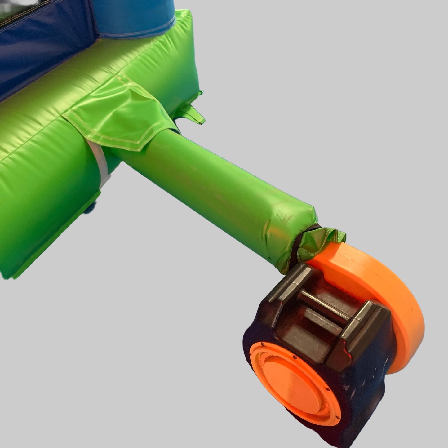 Close-up of a green and orange inflatable bounce house with a gray background