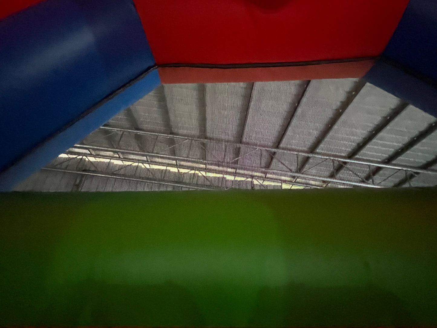 Colorful indoor play structure with a green slide and red, blue, and yellow sides.