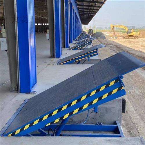 Set of loading ramps with blue and yellow safety stripes in an industrial setting.