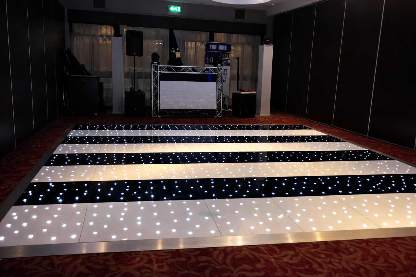 Black Starlit LED Dance Floor with black and white pattern in a room with dark walls and a stage.