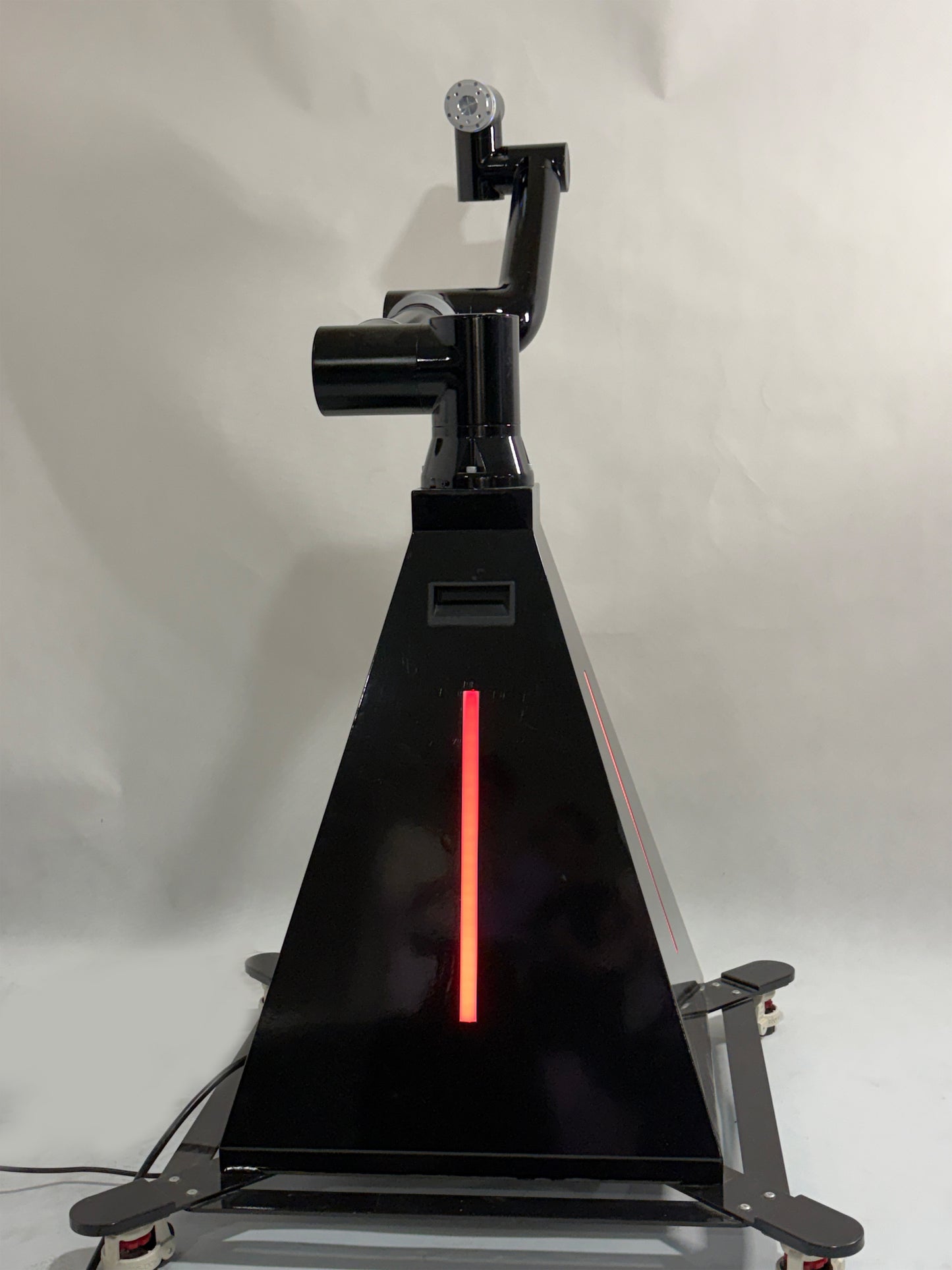 A black robotic arm photobooth with a colorful light stripe, designed for capturing images at events such as weddings and parties.