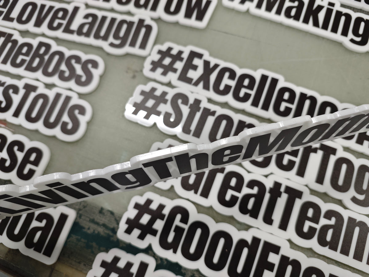 Collection of photobooth props with phrases like '#Excellence' and '#Strong' on a reflective surface.