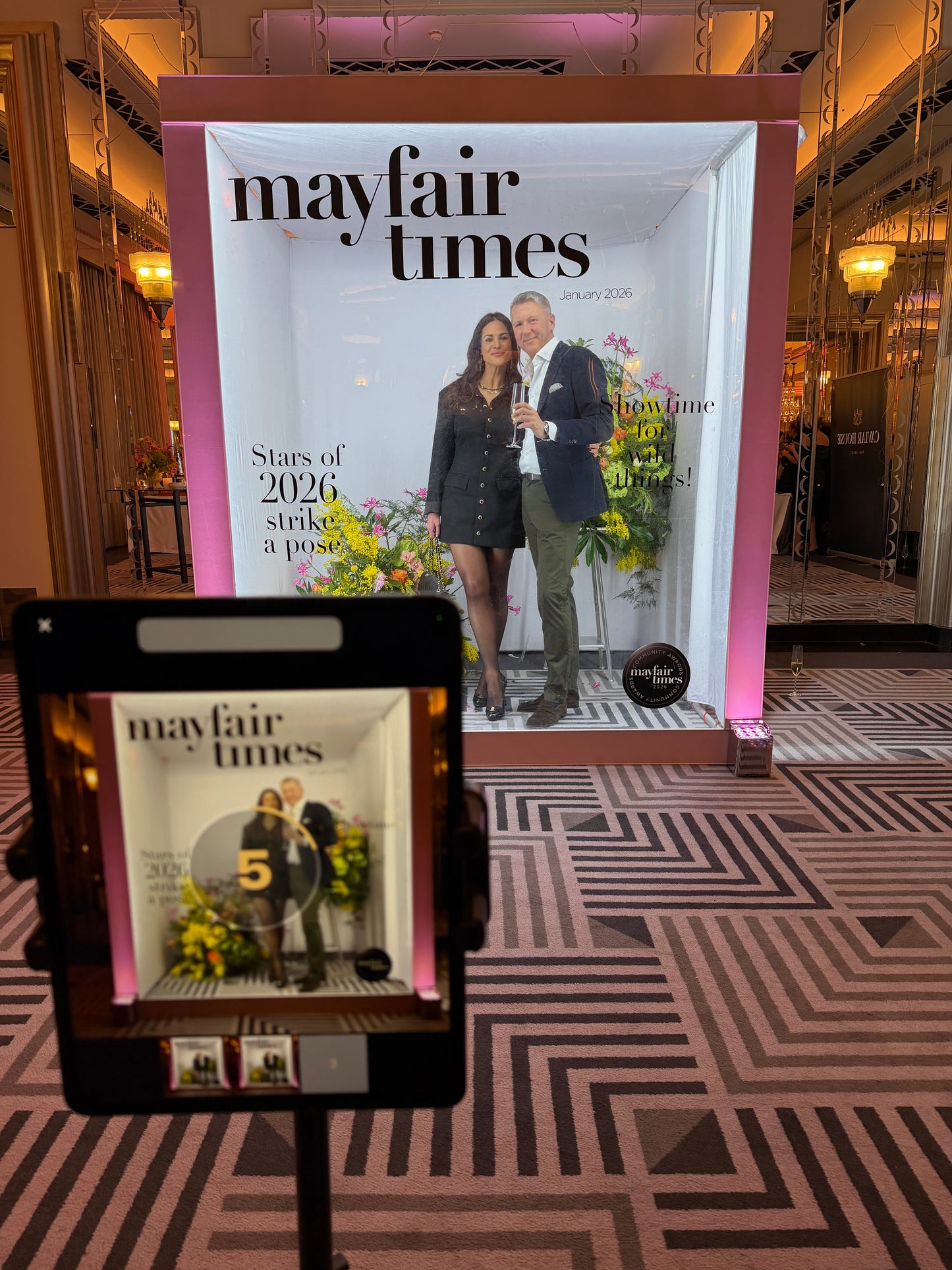 Mayfair Times magazine on a stand with a patterned floor in the background