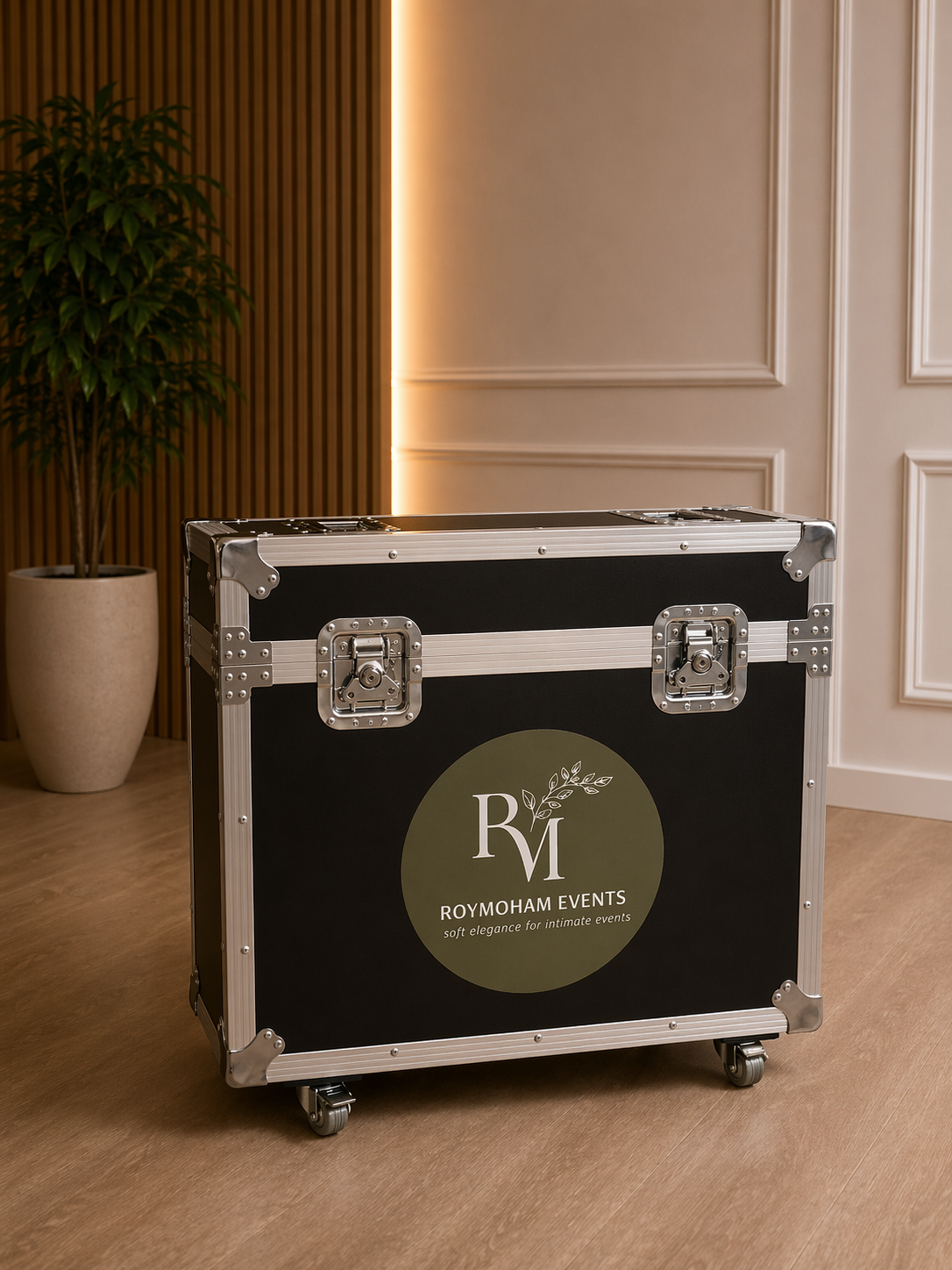 Black and silver flight case with 'Roy Moham Events' logo on a wooden floor.