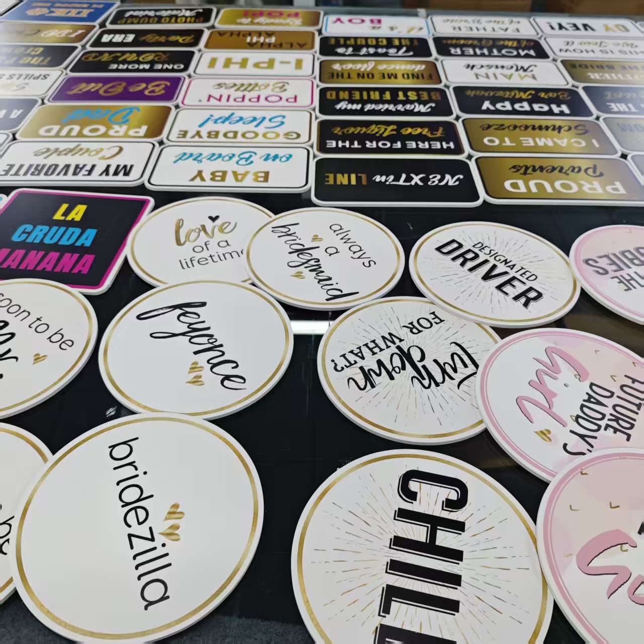 Collection of personalised photobooth props with various designs and text on a dark surface. 