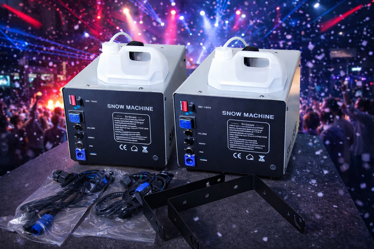 Two snow machine units on a stage with a crowd and colorful lights in the background.