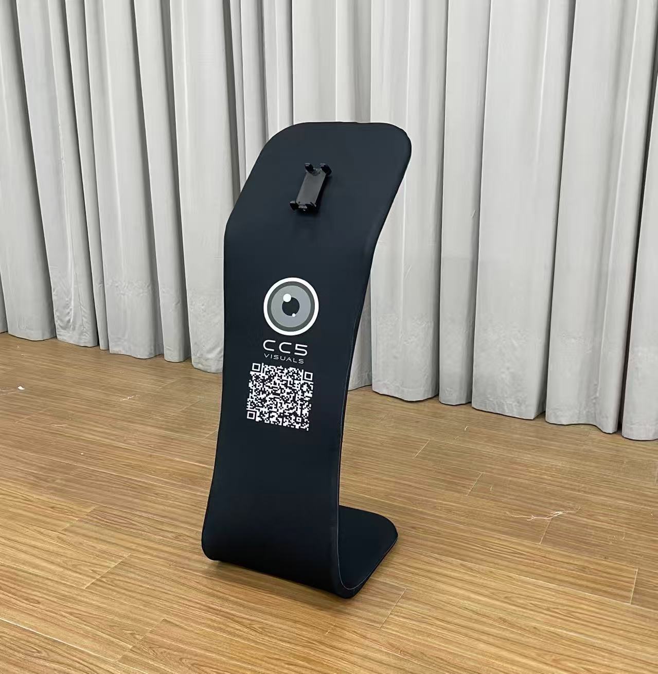 A black customisable tablet sharing station with CC5 Visuals logo on the side and a tablet mounted on top