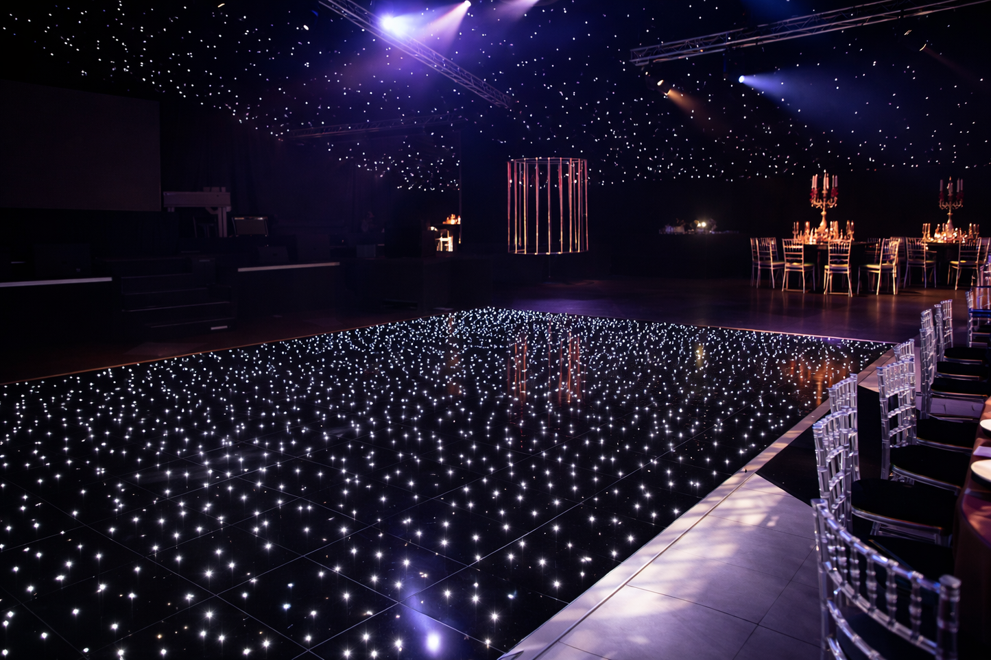 Starlit dance floor with purple lighting in a large indoor venue