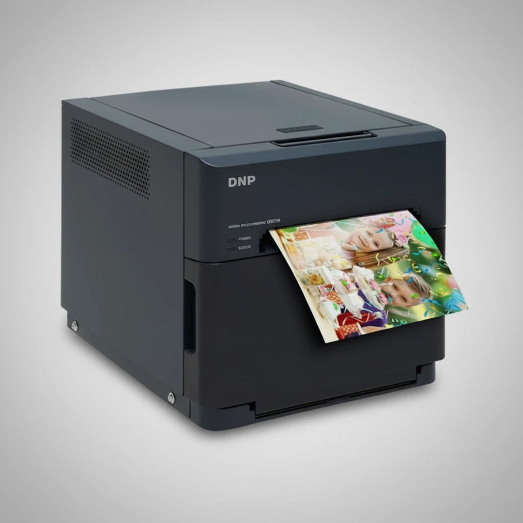 Black DNP photo printer with a stack of printed photos on a light gray background