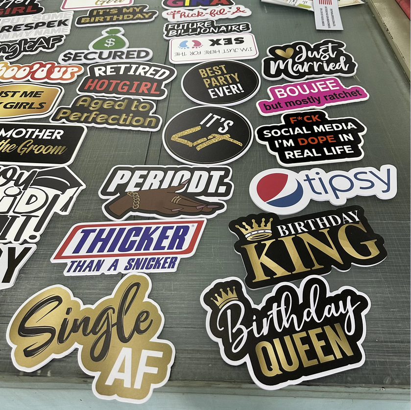 Collection of various photoboooth props with different designs and text on a surface.