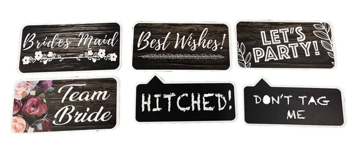 Collection of various photoboooth props with different designs and text on a surface.