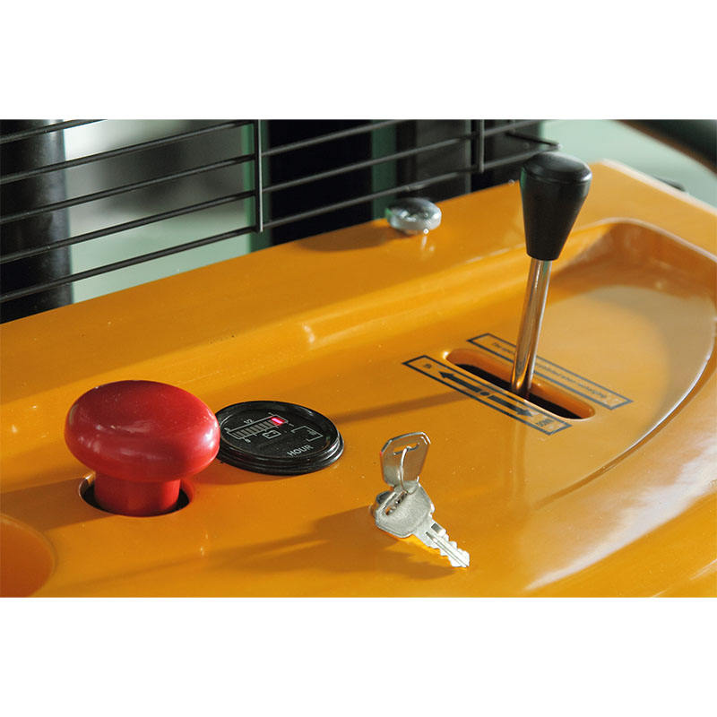 Close-up of a yellow forklift ignition area with a key, red knob, and black switch.