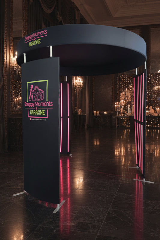 A black, circular, three-piece photobooth enclosure with integrated LED lighting, displayed against a white background.
