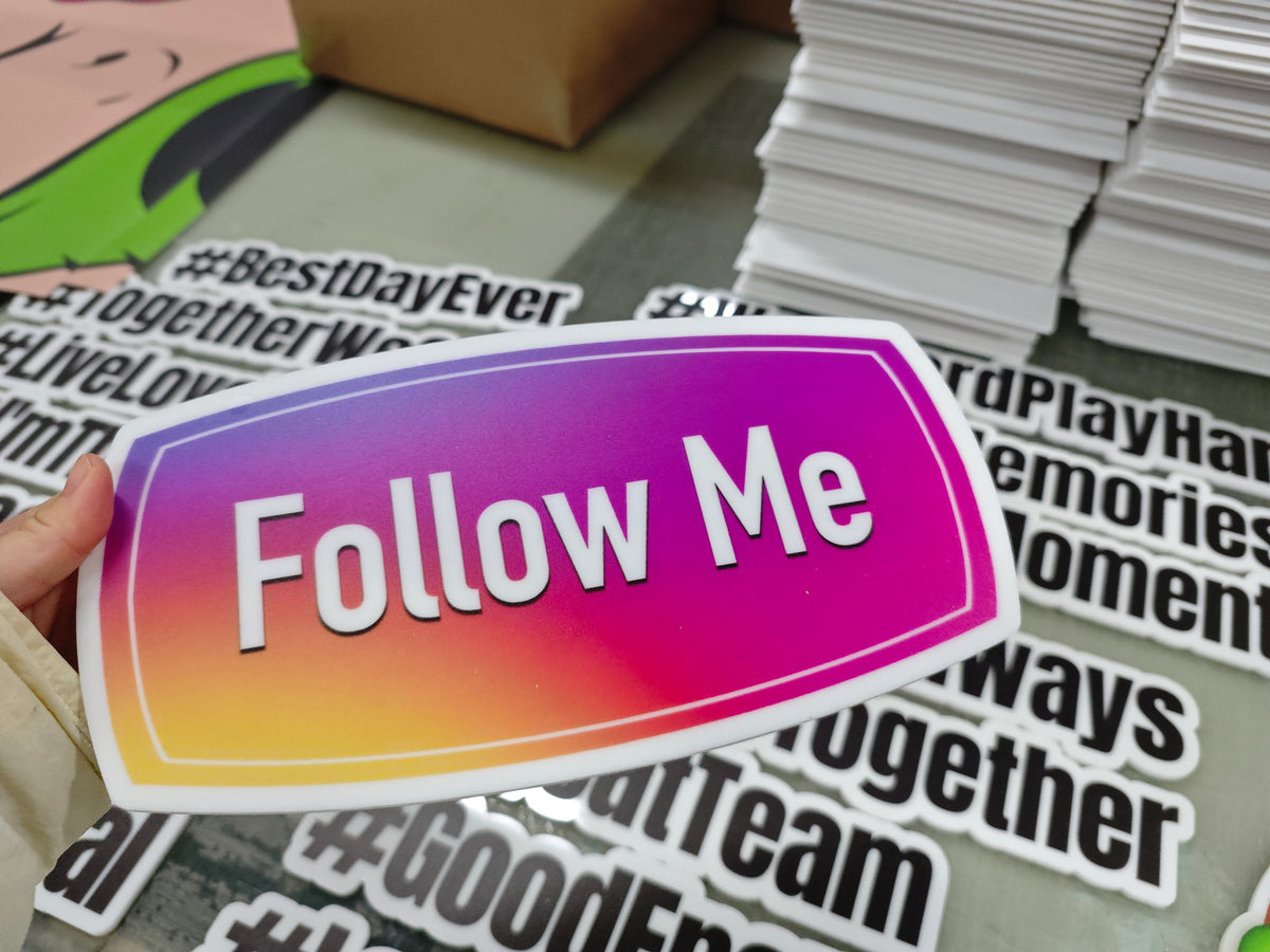 Colorful 'Follow Me' photobooth prop held over a stack of printed props with text.