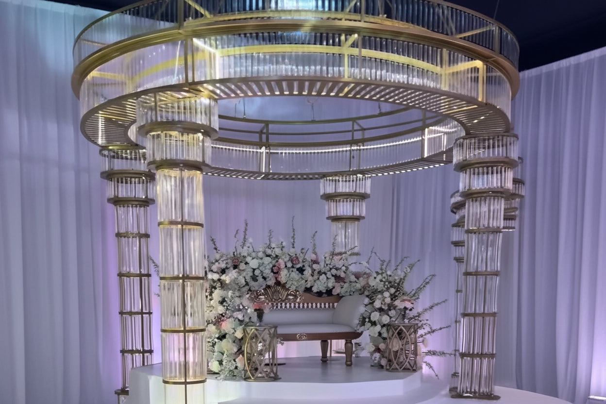 Decorative setup with floral arrangements and a large circular gold structure.