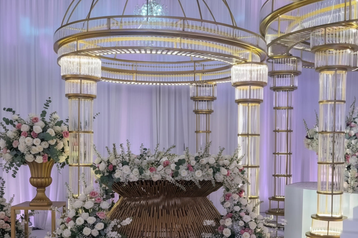 Decorative round gold mandap in a wedding setting with floral arrangements.