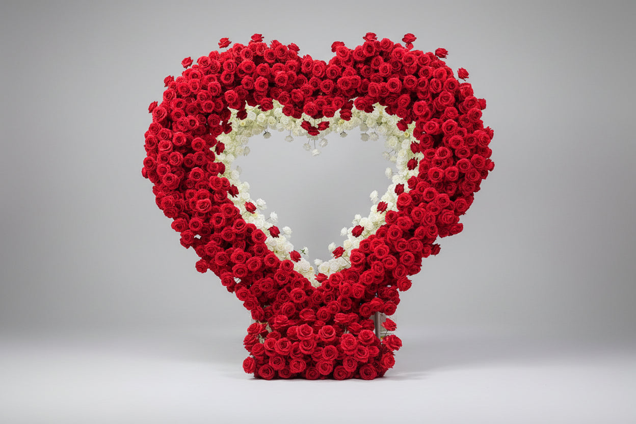 Large floral arch made of red and white flowers used for proposals and weddings set against a white studio background