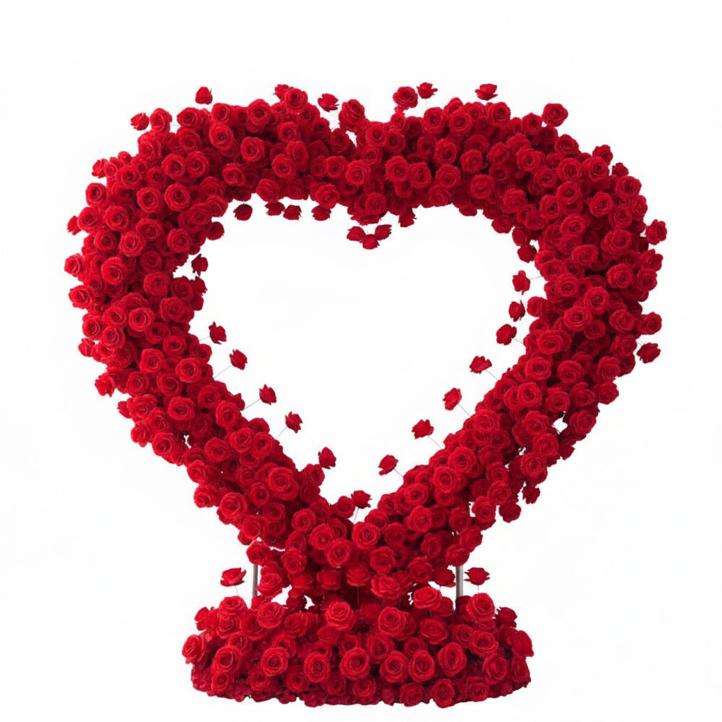 Heart-shaped arrangement of red roses used for proposals and weddings set against a white curtain background