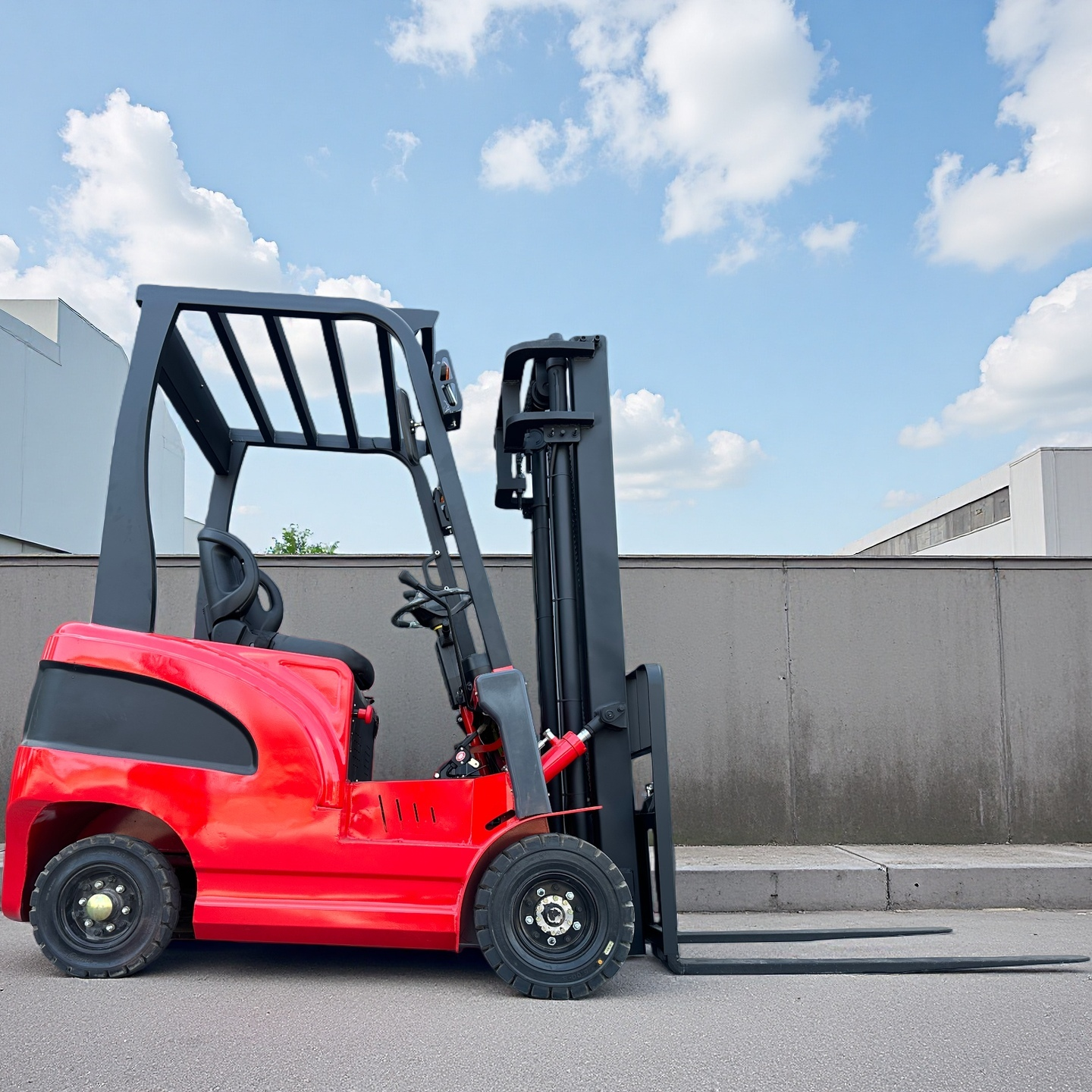 Red forklift with 4 wheels parked on a concrete surface 