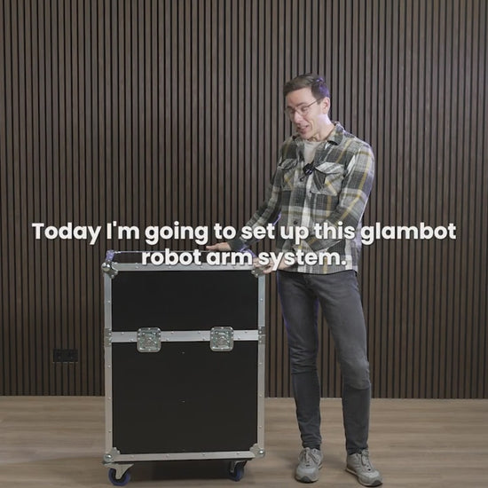 A black Glambot Photobooth Robot Arm mounted on a base with a camera attached to its end.