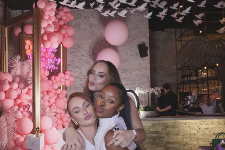 A white roaming robot photobooth with a DSLR camera mounted on a stand, featuring a screen for iPad control interface.