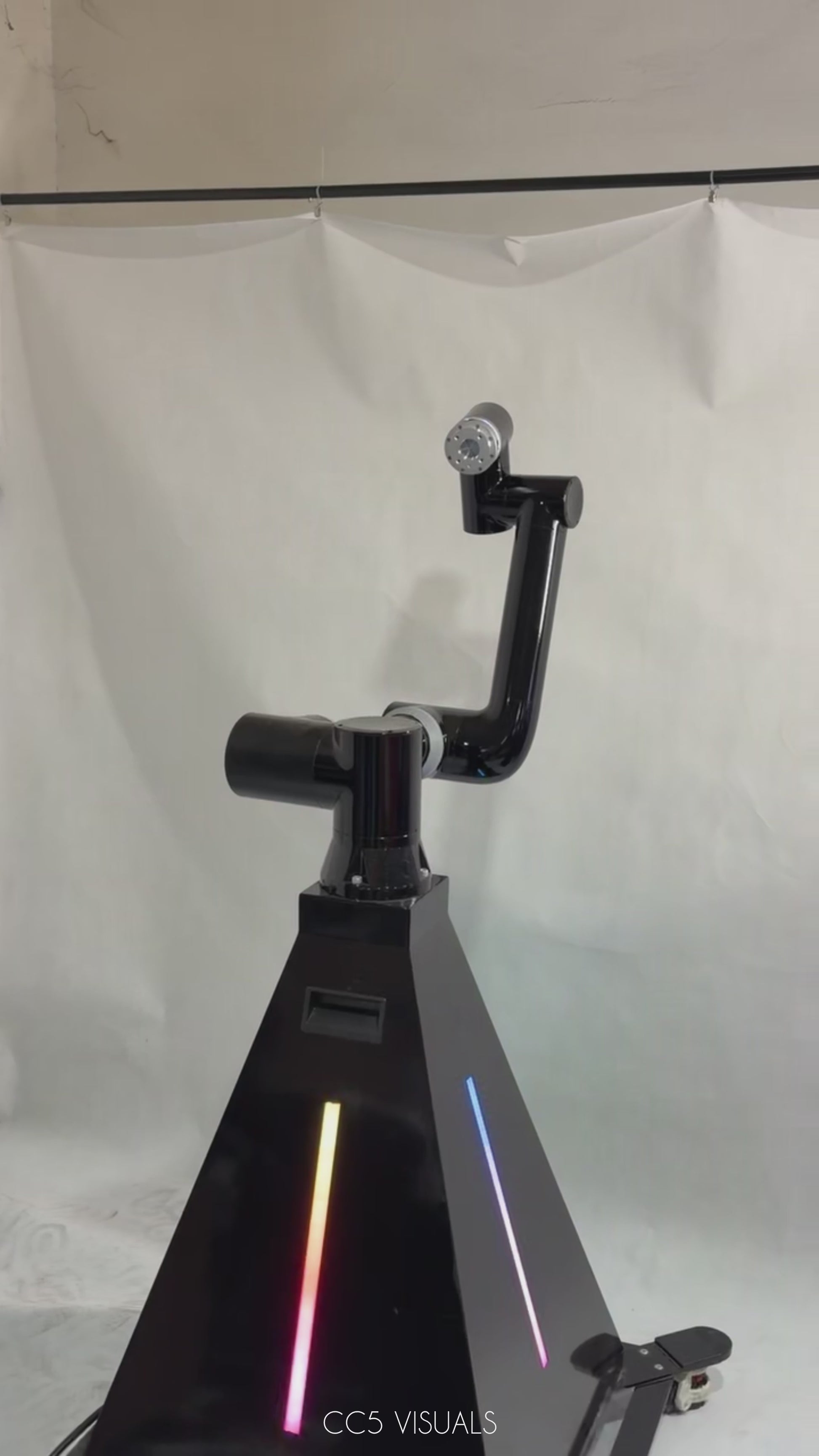 A black robotic arm photobooth with a colorful light stripe, designed for capturing images at events such as weddings and parties.