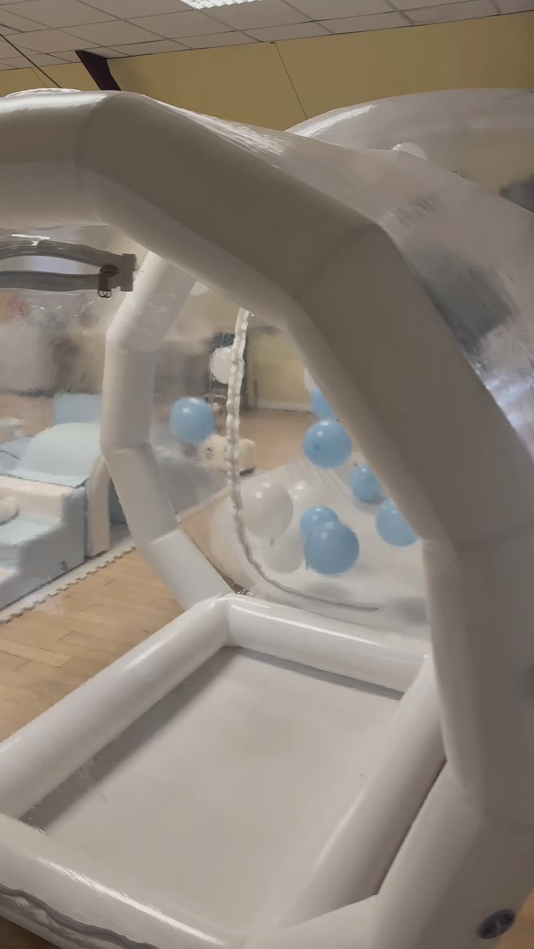 A clear inflatable dome-shaped bubble-house with colourful balloon inside for birthdays, celebrations, weddings, childrens birthdays 