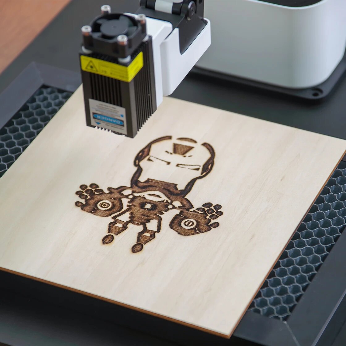 Laser engraving machine on a wooden board with a robot design.