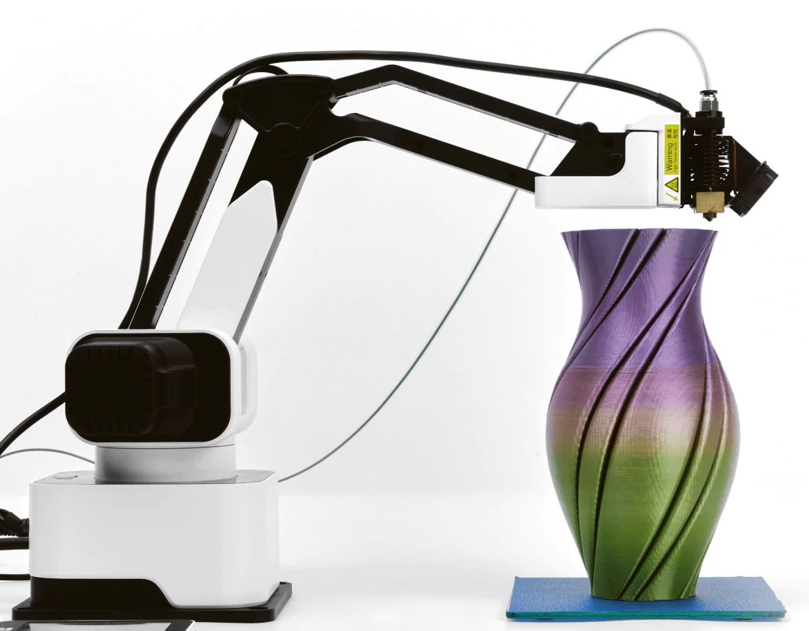 3D printing process with a robotic arm and printed vase on a white background