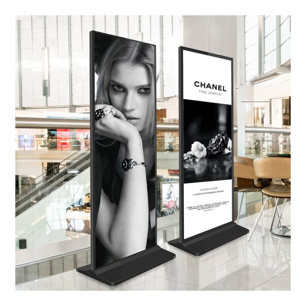 Two standing 43” LED Touchscreen Indoor Digital Kiosk Floor Standing display screens in a shopping mall setting, one featuring a model with jewellery and the other displaying Chanel branding.